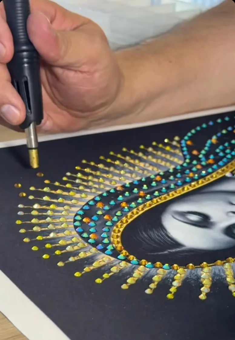 Manos aplicando cristales con calor sobre una imagen de la Virgen de Guadalupe